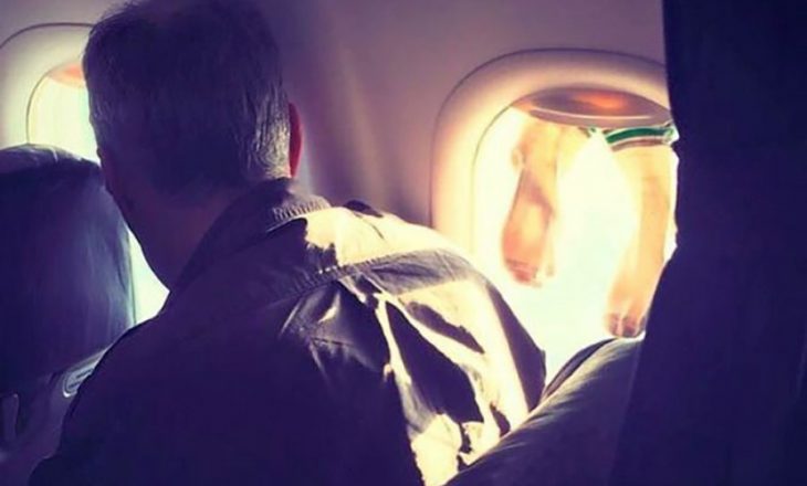 Udhëtari kapet duke tharë çorapet në dritaren e aeroplanit gjatë fluturimit